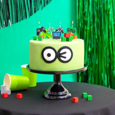 Bolo verde com decorações de comandos de jogo e texto COLORFUL GAME UP