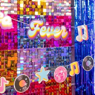 Decoração suspendida com palavra Fever e símbolos musicais sobre fundo colorido metalizado