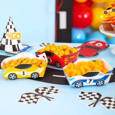 Caixas de snacks em forma de carros de corrida com bandeiras e decoração de festa.