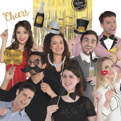 Grupo de pessoas a festejar com acessórios de Ano Novo e decoração brilhante