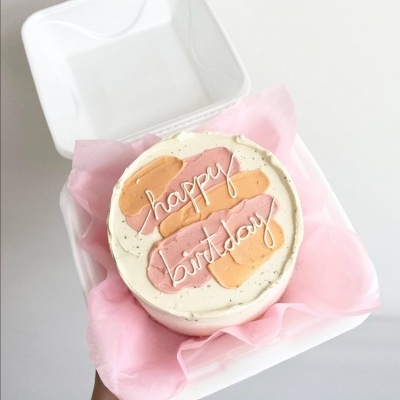 Bolo de aniversário decorado em caixa branca com papel cor-de-rosa