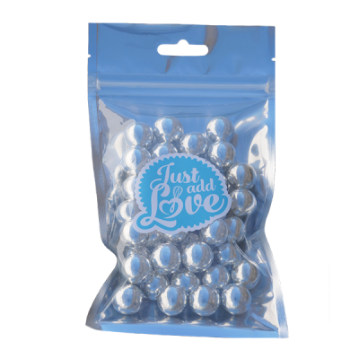 Embala transparente com bolas prateadas e etiqueta azul 'Just add Love'.