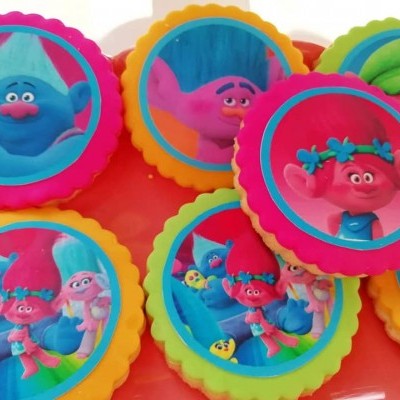 Botões decorativos coloridos com personagens Trolls em fundo laranja