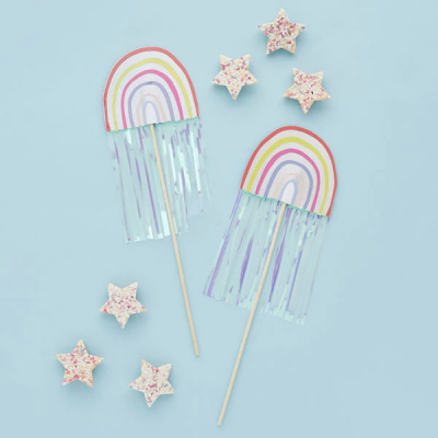 Decoração com arco-íris de papel e estrelas de espuma coloridas em fundo azul claro
