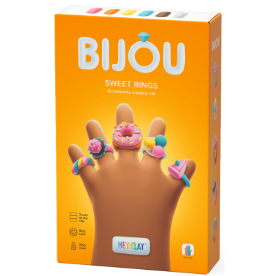 Caixa laranja do conjunto BIJOU Sweet Rings com anéis coloridos em argila expostos numa mão de plástico.