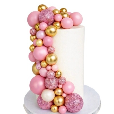 Bolo branco decorado com bolinhas rosa e douradas