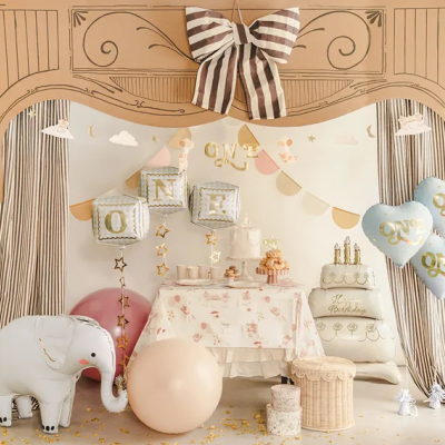 Decoração de festa infantil com balões ONE, cortinas às riscas e elefante inflável