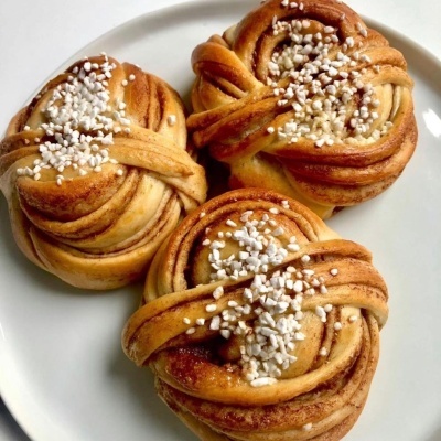 Três bolos de canela com açúcar em pérolas num prato branco