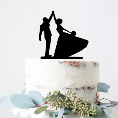 Bolo branco com topper preto de casal a dançar e folhas verdes na base