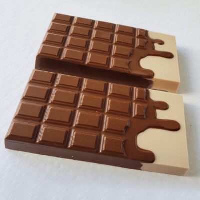 Duas barras de chocolate de leite com cobertura parcial de chocolate branco em fundo branco