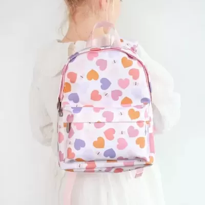 Mochila infantil branca com corações coloridos nas costas de criança