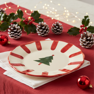 Prato de cerâmica decorativo de Natal sobre mesa vermelha com decoração festiva