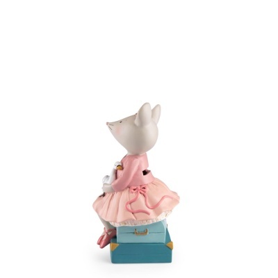 Estatueta de ratinho vestido rosa sentado em malas azuis segurando cisne
