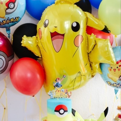 Festa com balões, bolo e boné decorados com tema Pokémon e Pikachu