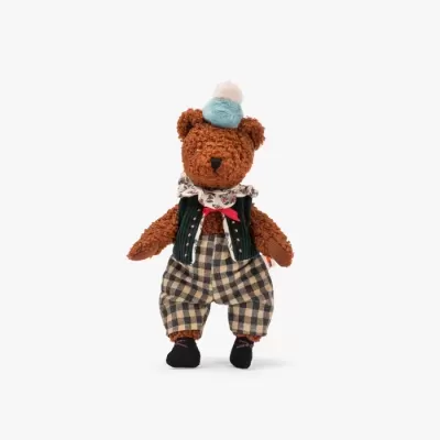Ursinho de peluche vestido com calças aos quadrados, colete, lenço e chapéu azul com pompom