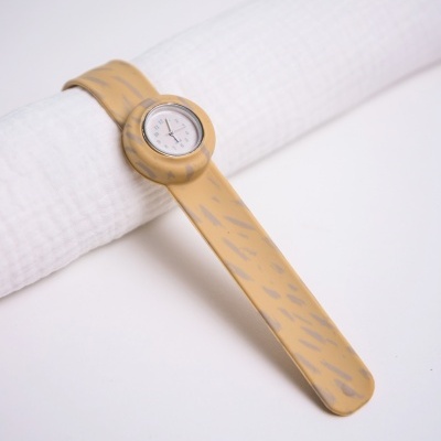 Relógio de pulso amarelo com padrão cinza sobre tecido branco texturizado