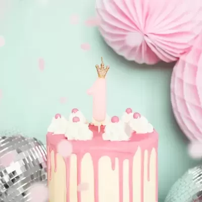 Bolo decorado com vela número 1 e decoração rosa e prateada