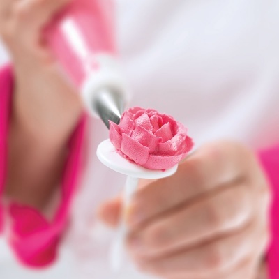 Bico de confeitar com creme rosa em formato de flor