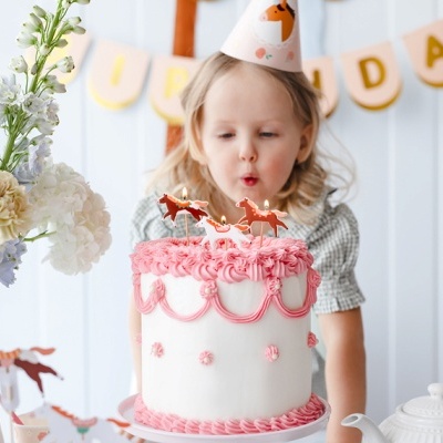 Bolo de aniversário decorado com glacê branco e rosa, flores e banner BIRTHDAY