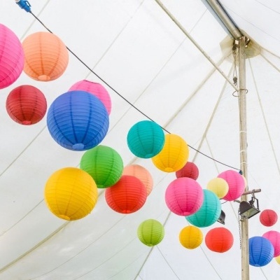 Lanternas de papel coloridas penduradas numa tenda branca