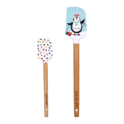 Duas espátulas de silicone com cabo de madeira, padrão de gotas coloridas e pinguim festivo