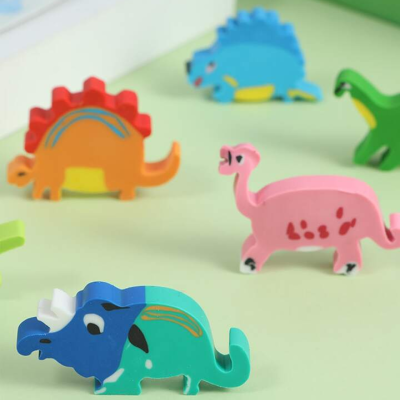 Brinquedos de madeira em forma de dinossauros coloridos sobre superfície verde clara