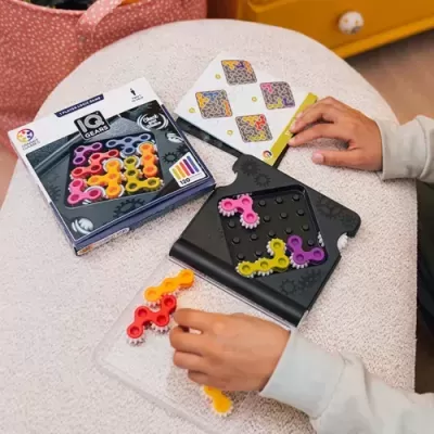 Jogo de quebra-cabeças IQ Gears com peças coloridas e tabuleiro preto em mesa clara