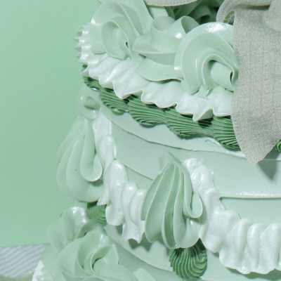 Bolo decorado com chantilly verde claro e laço verde pálido