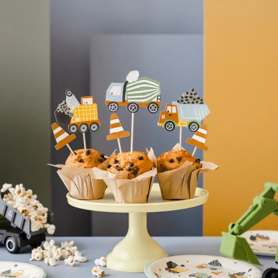 Muffins com toppers de carrinhas de construção e cones, base de bolo creme, pipocas e brinquedos de construção verdes