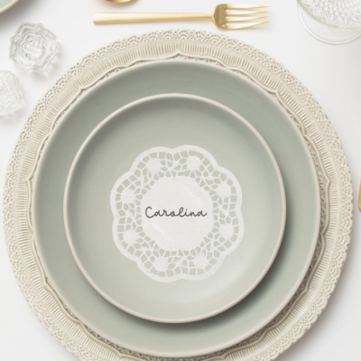 Conjunto de pratos redondos com padrão rendilhado e talheres dourados