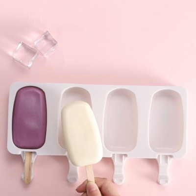 Forma para gelado branca com dois gelados desenformados roxo e branco sobre fundo rosa