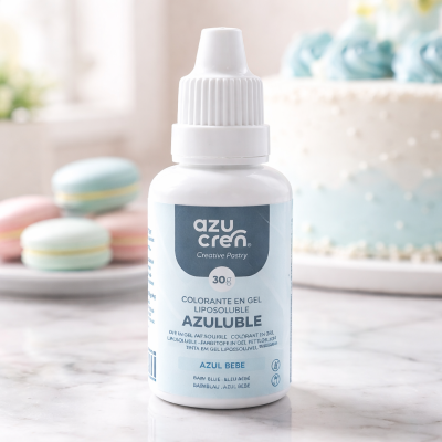 Frasco de corante gel lipossolúvel azul bebê Azucren sobre superfície de mármore com bolo e macarons ao fundo