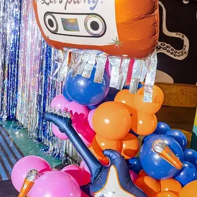 Balões decorativos para festa em cores vivas, com balão cassete LETS PARTY e guitarra azul