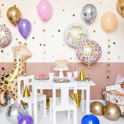 Decoração de festa de aniversário infantil com balões coloridos, figura de girafa inflável e mesa branca com bolo