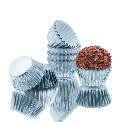 Formas de papel prateadas para doces com brigadeiro sobre superfície refletora