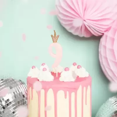 Bolo de aniversário com vela número 9 coroa, cobertura branca e rosa, decoração chantilly e pérolas cor-de-rosa