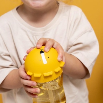 Copo infantil amarelo transparente com tampa divertida, criança sorridente segurando o copo
