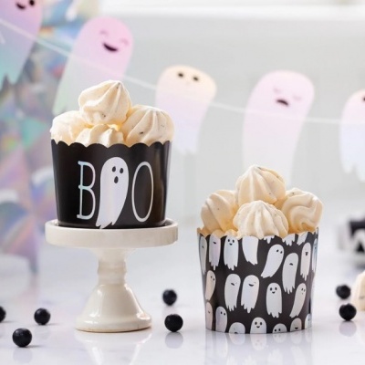 Dois cupcakes de Halloween em embalagens pretas decoradas com fantasmas brancos