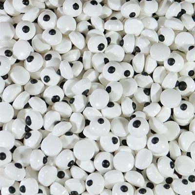 Peças pequenas redondas brancas com pontos pretos no centro, aparentando olhos estilizados