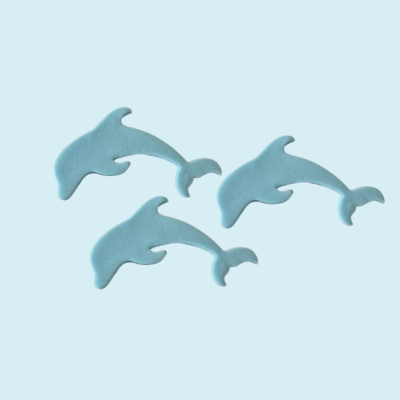 Três golfinhos azuis de cerâmica ou plástico fosco em fundo azul claro