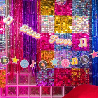 Decoração brilhante de festa com cortinas metálicas coloridas e guirlanda temática disco