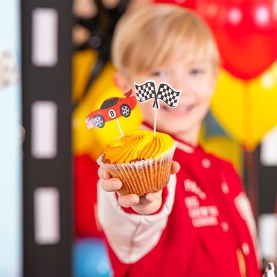 Cupcake com cobertura amarela e decorações de corrida