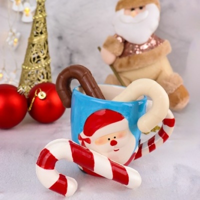 Caneca azul de Pai Natal com bengalas de açúcar vermelhas e brancas