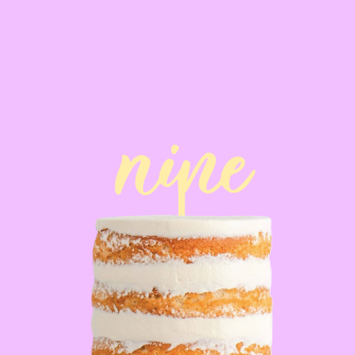 Bolo semi-naked castanho e branco com topo decorativo a dizer 'nine'