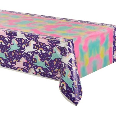 Toalha de mesa colorida com padrão de unicórnios em fundo roxo e centro em cores pastel