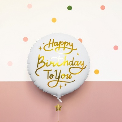 Balão branco redondo com texto dourado 'Happy Birthday To You' contra parede com padrão de pontos coloridos