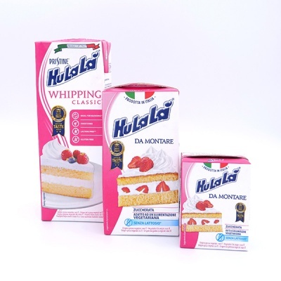 Embalaegens rosa e branca de creme para bater Hula La com imagem de bolo com chantilly e morangos.