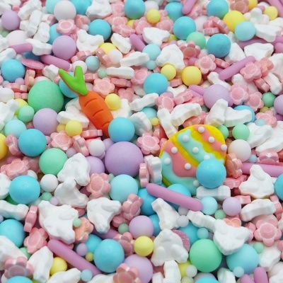 Confeites coloridos em tons pastel com temas de Páscoa, incluindo coelhos, cenoura e ovo decorado