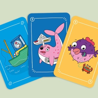 Cartas de jogo coloridas com desenhos de barco, baleia e peixe-puff.