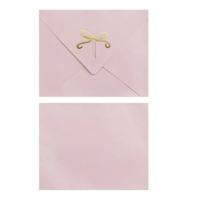 Envelope e cartão rosa claro com selo dourado em laço